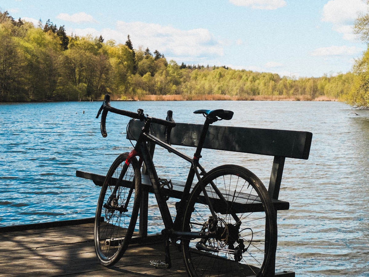 A bicycle resting beside a quiet lake