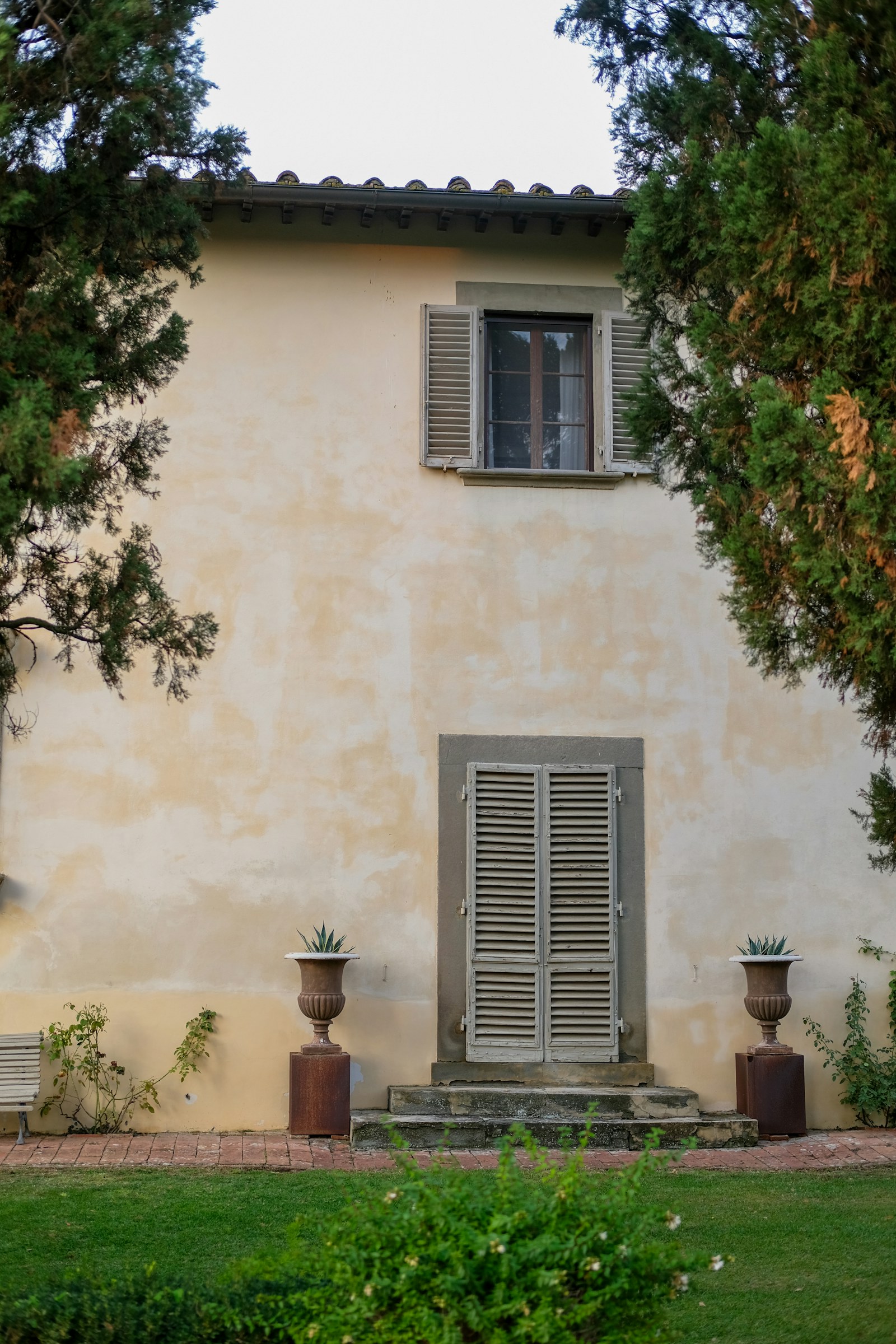A Tuscan villa with green shutters and stone steps